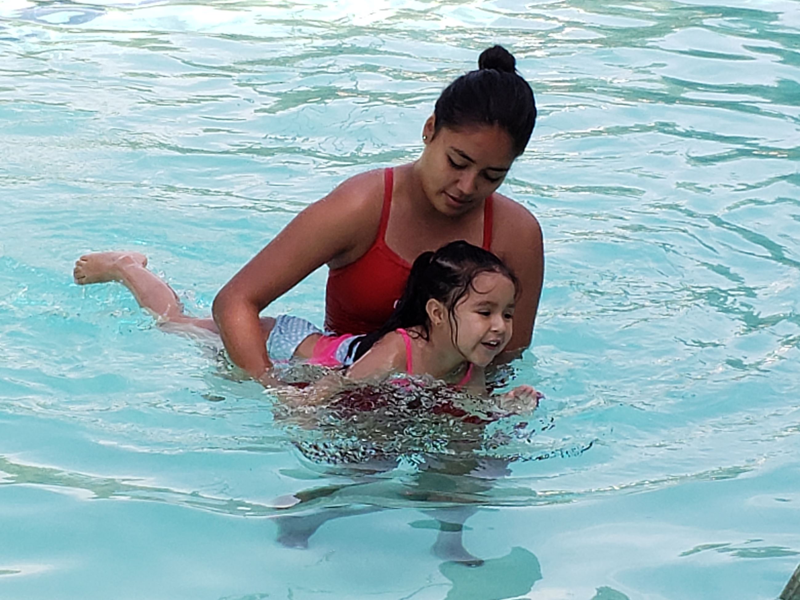 Swim lesson instructor with girl in pool